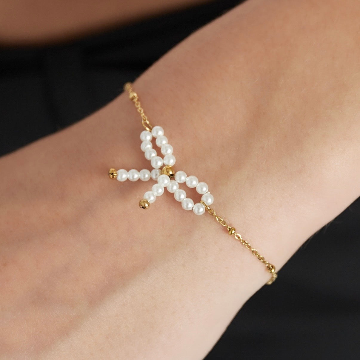 Armbandje- parel strikje goudkleurig