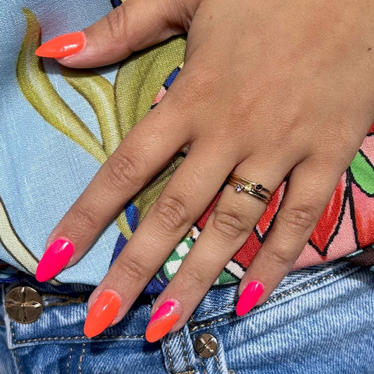 Vrouwelijke hand met kleurrijke nagels en stainless steel ringen van Jewelrybyceline