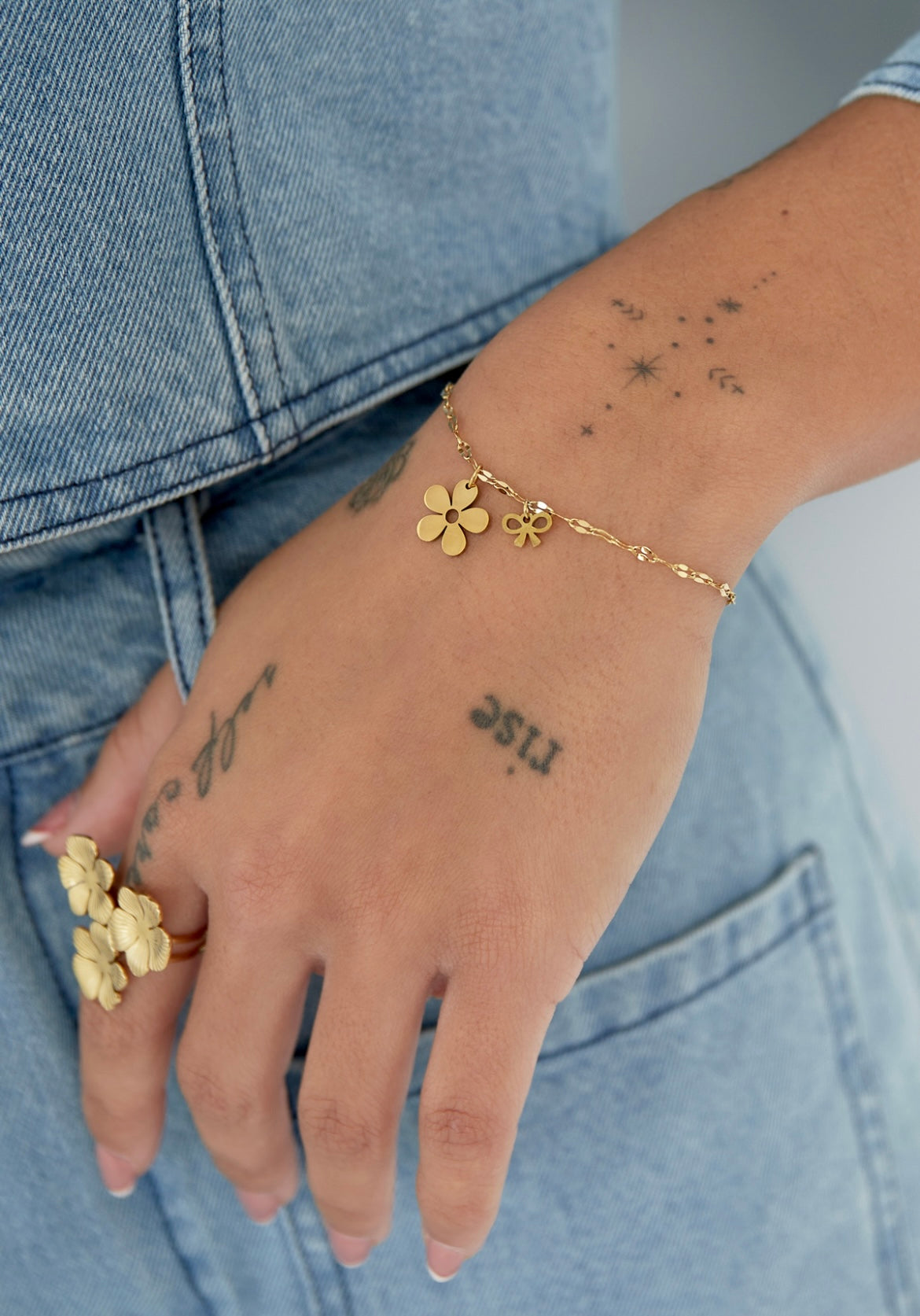 Armbandje- bloemetje strikje goudkleurig