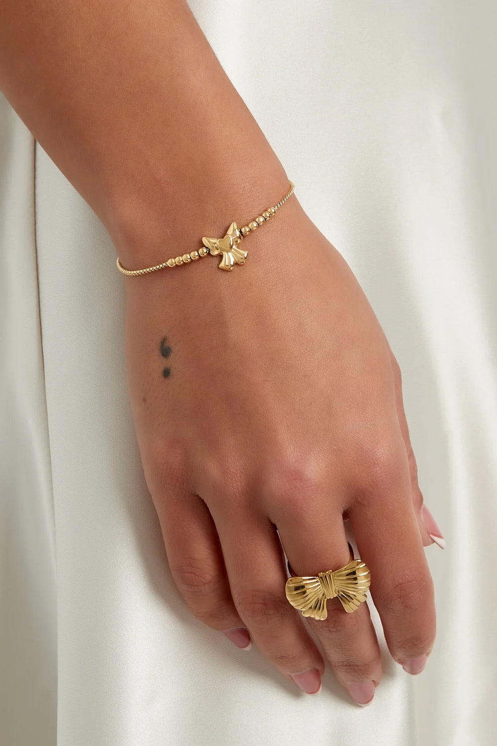 Armbandje- klein strikje goudkleurig