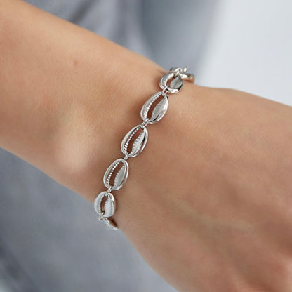 Zilverkleurig armbandje met schelpjes bedeltjes gedragen om de pols - Jewelrybyceline