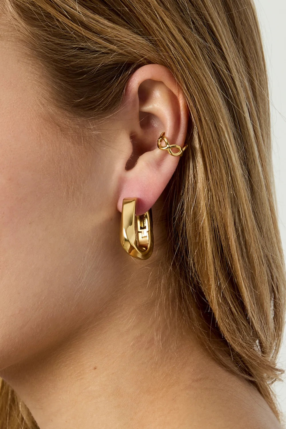 goudkleurige earcuff met print in oor