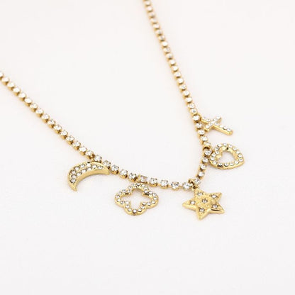 Goudkleurige stainless steel ketting met bedels van maan, ster, hart en kruis met steentjes. Foto van de zijkant 