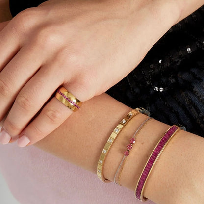 goudkleurige  stainless steel ring met roze steentjes en brede band gedragen om de vinger